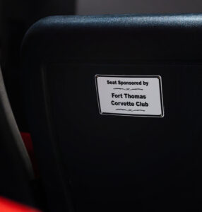 Close-up of a black theater seat at the National Corvette Museum with a plaque reading “Seat Sponsored by Fort Thomas Corvette Club,” representing a sponsored seat in the Chevrolet Theater.